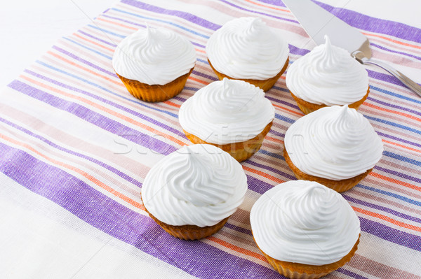 White cupcakes row on the linen napkin Stock photo © TasiPas