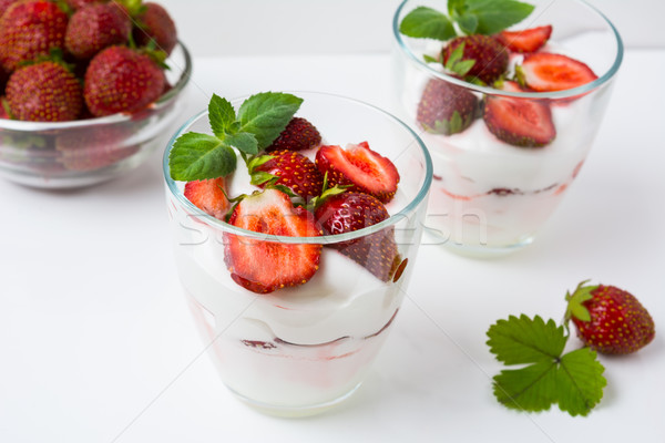 Fresh strawberries dessert layered with yogurt on white backgrou Stock photo © TasiPas