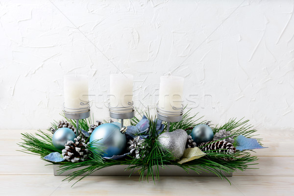 Stock photo: Christmas table centerpiece with three candles and blue ornament