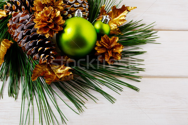 Christmas background with green ornaments and golden pine cones  Stock photo © TasiPas