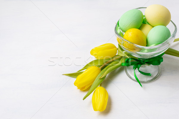 Easter green and yellow painted eggs in the vase and tulips, cop Stock photo © TasiPas