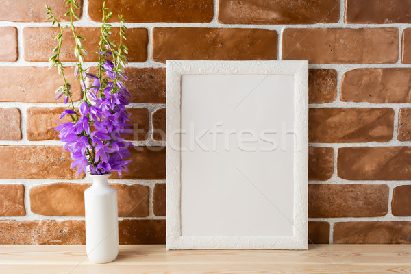 White frame mockup with campanula bouquet near exposed brick wal Stock photo © TasiPas