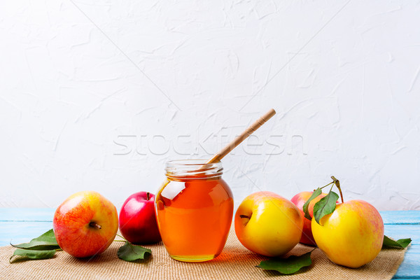 Honey jar with dipper and apples on white background Stock photo © TasiPas