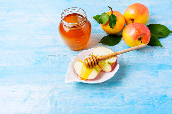 Apple slices with honey on blue wooden background Stock photo © TasiPas