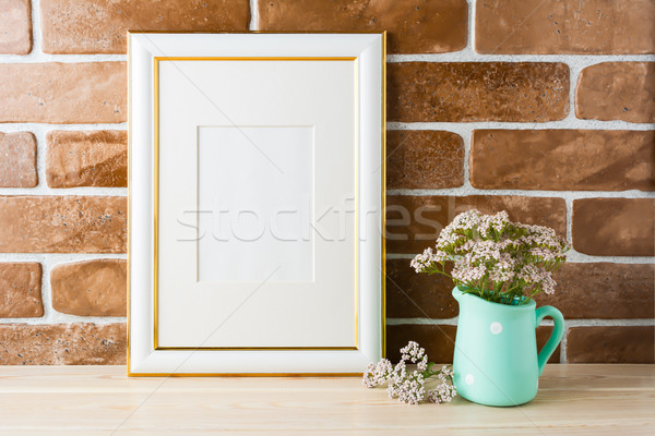 Gold decorated frame mockup soft pink flowers exposed brick wall Stock photo © TasiPas