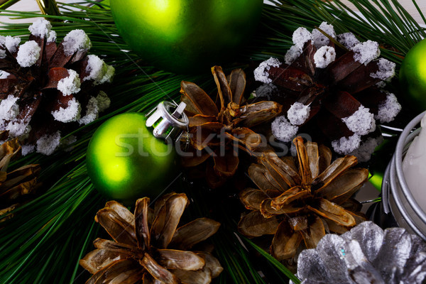 Christmas background with snowy pinecone and green ornaments Stock photo © TasiPas