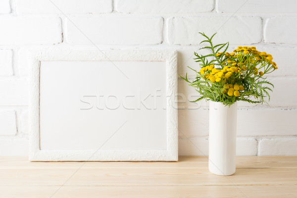 White landscape frame mockup with yellow flowers near painted br Stock photo © TasiPas