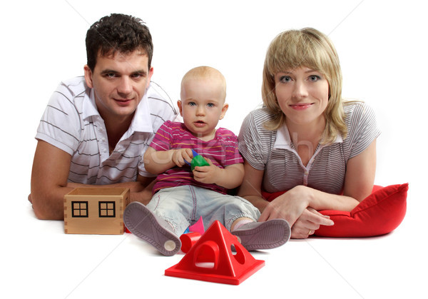 happy young family lying on the floor on red cushions, white bac Stock photo © Tatik22