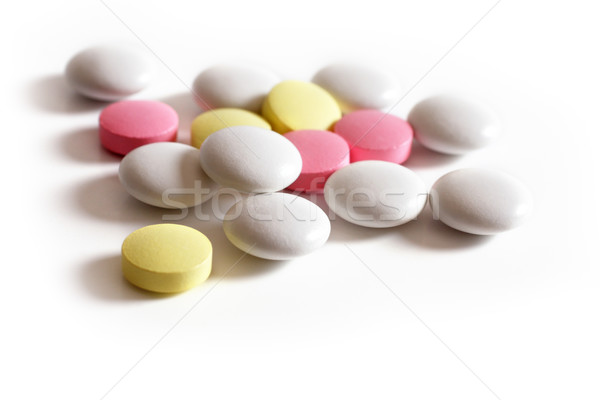 Stock photo: pink, yellow  and white tablets on a white background.