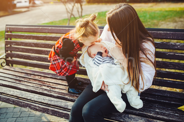 mother and two daughters rest on a bench Stock photo © tekso