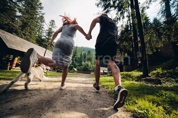 couple runs on road in the nature with dog Stock photo © tekso