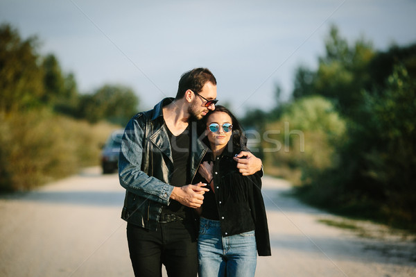Young happy romantic couple walking along road Stock photo © tekso