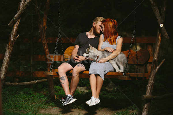 beautiful couple together with dog on a swing Stock photo © tekso