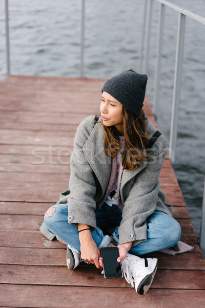 Stock photo: Young pretty girl on wooden bench on old pier
