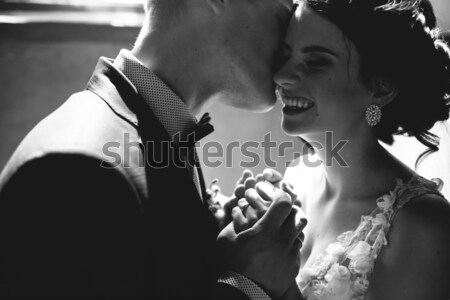 Stock photo: bride and groom on the background of a window.