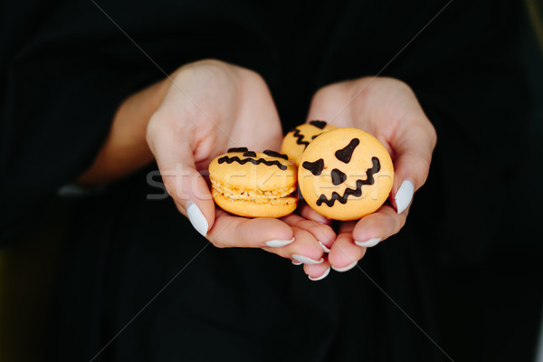 Stock photo: woman holding a biscuit for Halloween