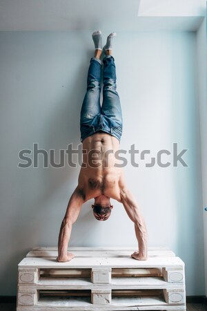Człowiek stwarzające kamery stałego do góry nogami ściany Zdjęcia stock © tekso