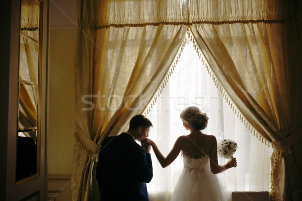 Stock photo: bride and groom standing in front of window