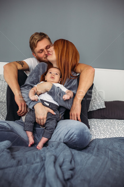 Stock photo: Happy family with newborn baby on the bed