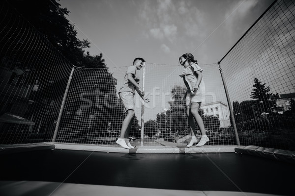 Couple jumping on trampoline in the park Stock photo © tekso