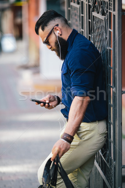 bearded man standing and listening to music Stock photo © tekso