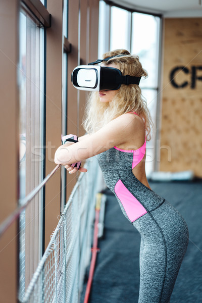 Beautiful girl in the gym with VR headset Stock photo © tekso