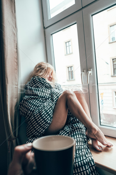 girl sitting on a window in a blanket Stock photo © tekso