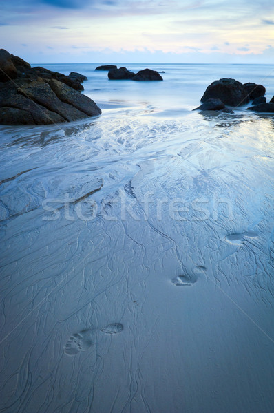 Praia crepúsculo pegadas areia água pôr do sol Foto stock © THP