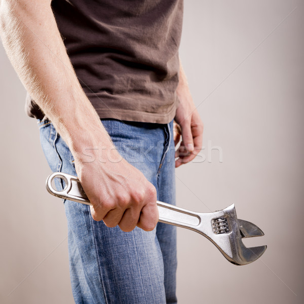 Mann halten verstellbarer Schraubenschlüssel junger Mann Kleidung Stock foto © THP