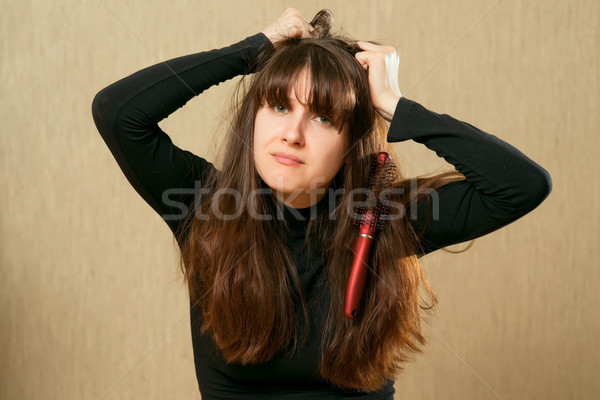 Hairbrush in female hair Stock photo © timbrk