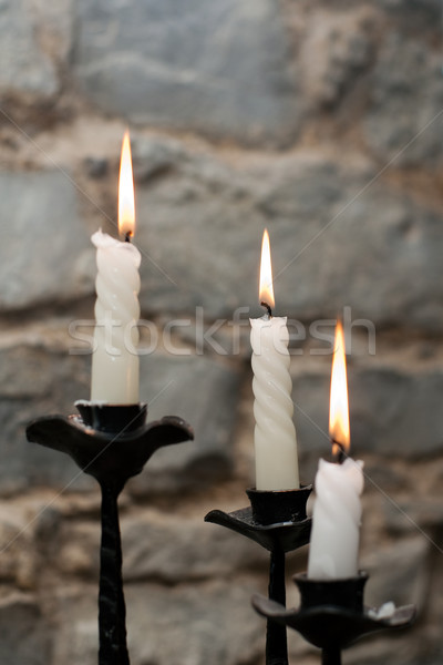 Trois bougies chandelier mur de pierre feu [[stock_photo]] © timbrk