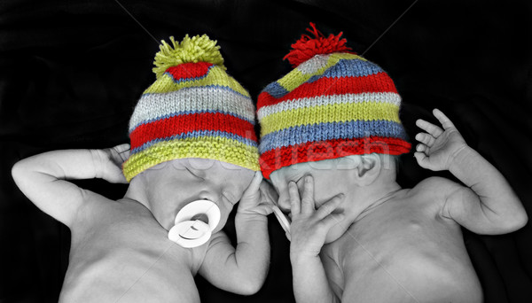 New born twins with colorful striped hats Stock photo © tish1