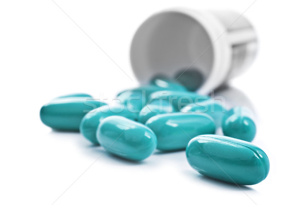 Blue pills an pill bottle on white background Stock photo © tish1