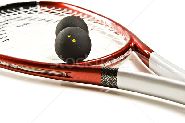 Close up of a red and silver squash racket and ball on a white background with space for text Stock photo © tish1