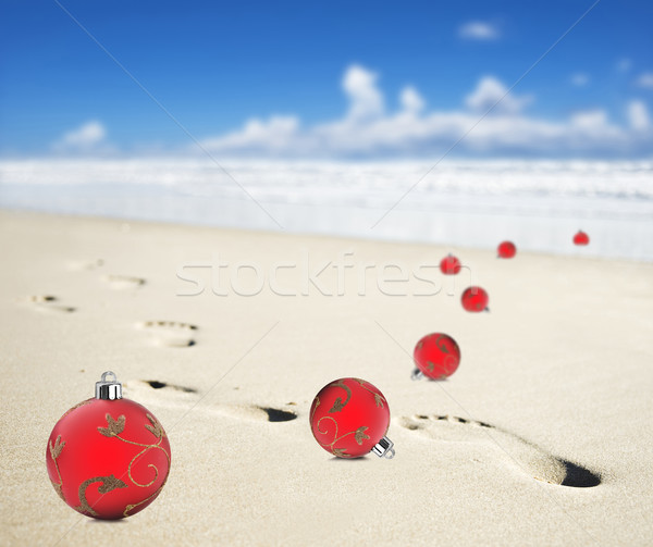 Christmas baubles on a beach with footprints Stock photo © tish1