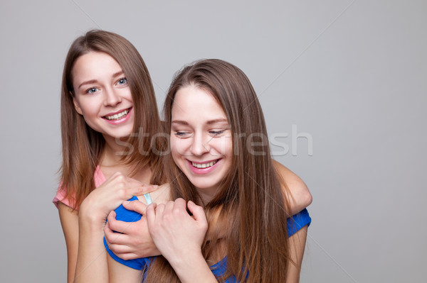 Studio portait of young twin sisters embracing Stock photo © tommyandone