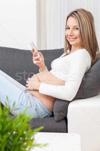 Gyönyörű terhes nő megnyugtató otthon kanapé nő Stock fotó © tommyandone