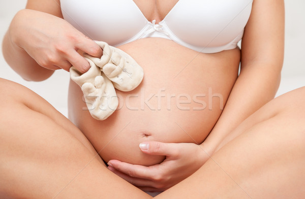 Terhes nő tart pár pici cipők babacipők Stock fotó © tommyandone