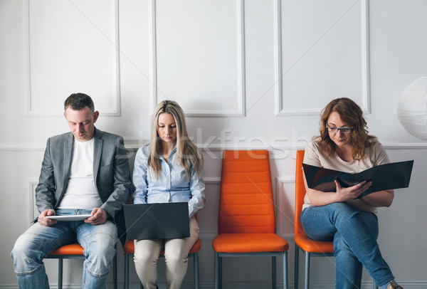 Group of creative people sitting on chairs in waiting room Stock photo © tommyandone