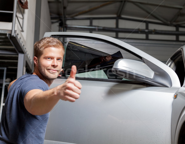 Stock photo: Applying tinting foil onto a car window 