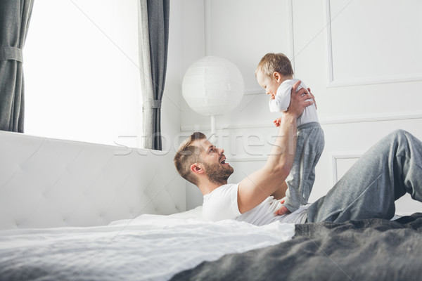 Happy father with his son playing at home on the bed Stock photo © tommyandone