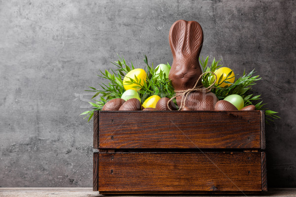 Traditional Easter chocolate bunny and eggs inside a wooden crate Stock photo © tommyandone