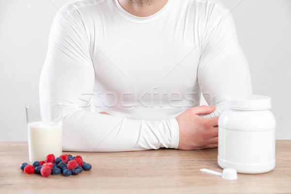 Stock photo: Closeup on a man with nutiotion supplements on table