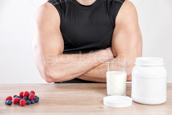 Stock photo: Closeup on a man with nutiotion supplements on table