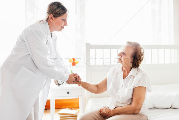 Providing care for elderly. Doctor visiting elderly patient at home.  Stock photo © tommyandone