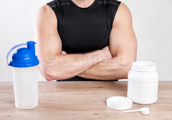 Stock photo: Closeup on a man with nutiotion supplements on table