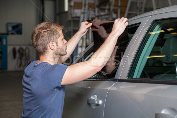 Applying tinting foil onto a car window in a workshop Stock photo © tommyandone