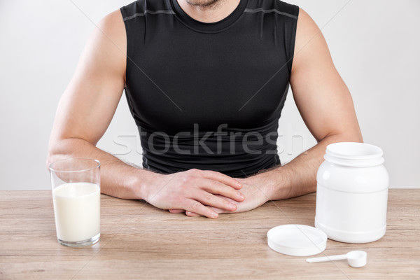 Stock photo: Closeup on a man with nutiotion supplements on table