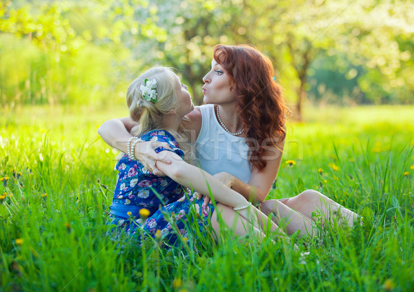 Portrait of happy mother and young daughter with heart in a beautiful blooming fruit garden with whi Stock photo © traza