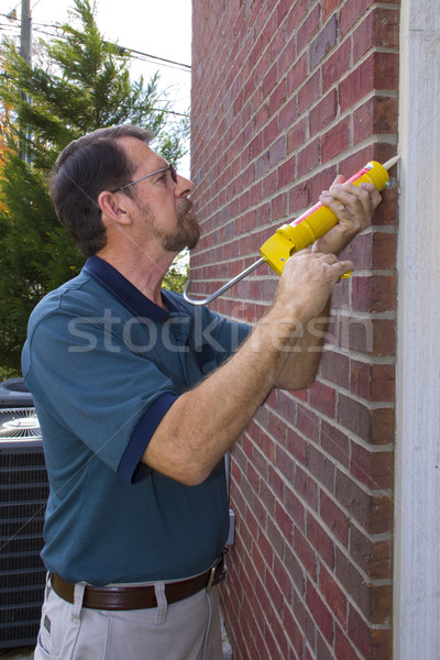 Stock photo: Contractor filling exterior wall cracks